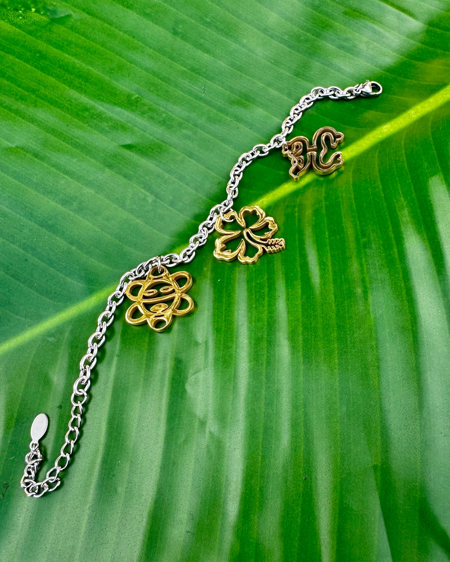 Puerto Rican jewelry bracelet featuring Maga flower, Coquí frog, and Sol Taíno charms in two-tone stainless steel.