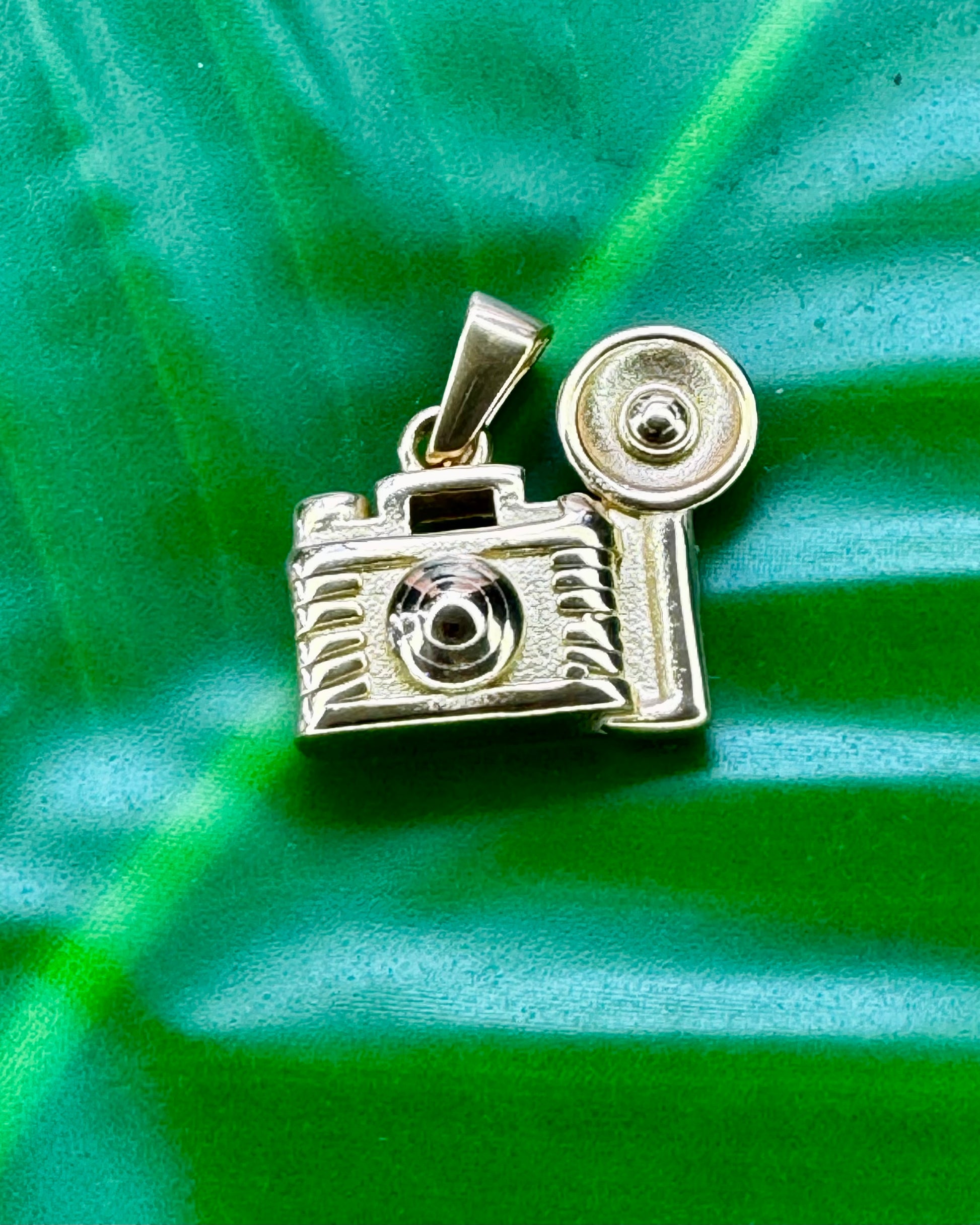 Camera charm in gold stainless steel referencing Bad Bunny’s song about taking more pictures