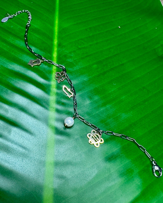 Two-tone Puerto Rican charm bracelet with Flor de Maga, Sol Taíno, Garita del Morro, and pearl charms.