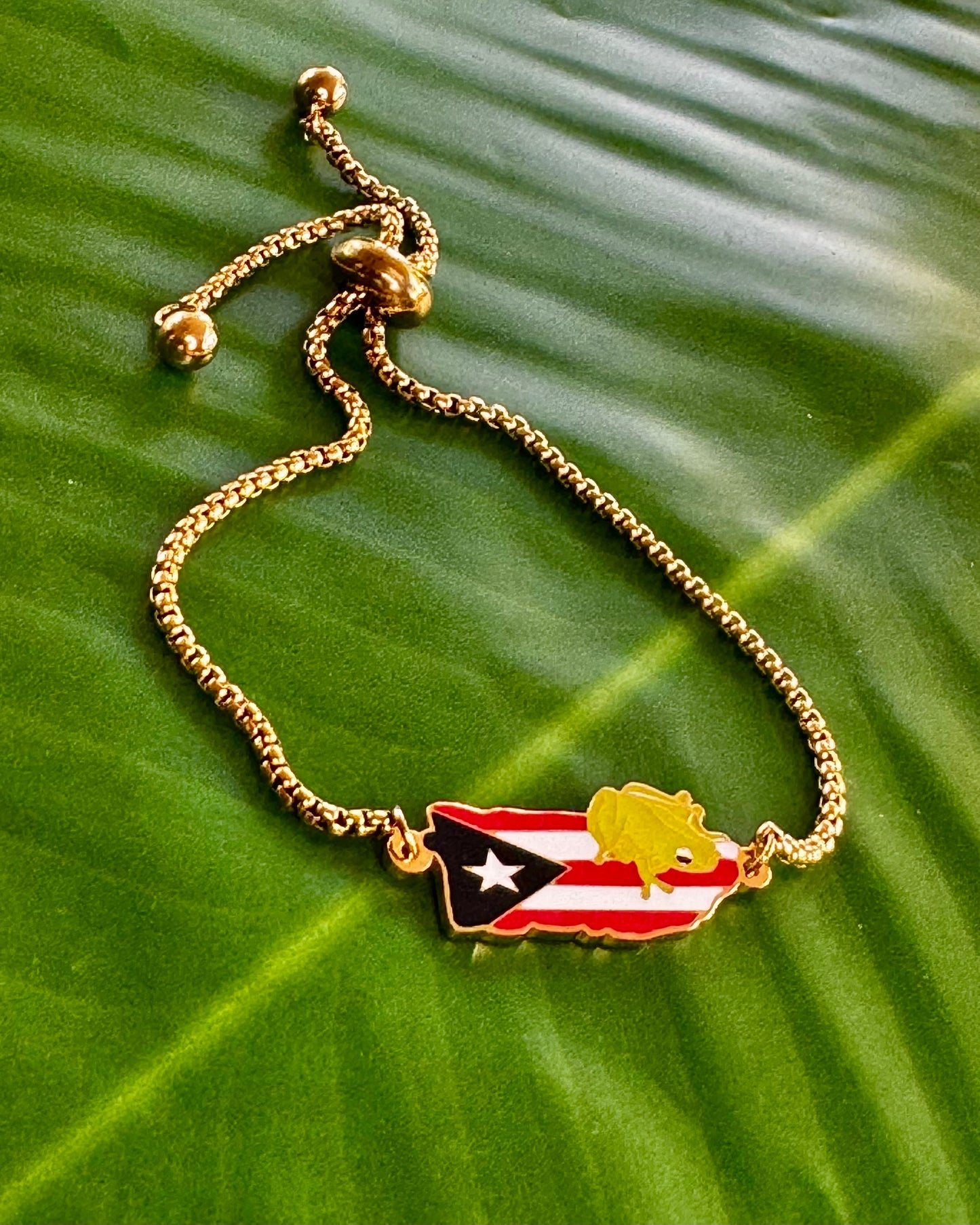 Gold stainless steel bracelet with Puerto Rico flag charm accented by a small Coquí in the corner, representing Puerto Rican pride