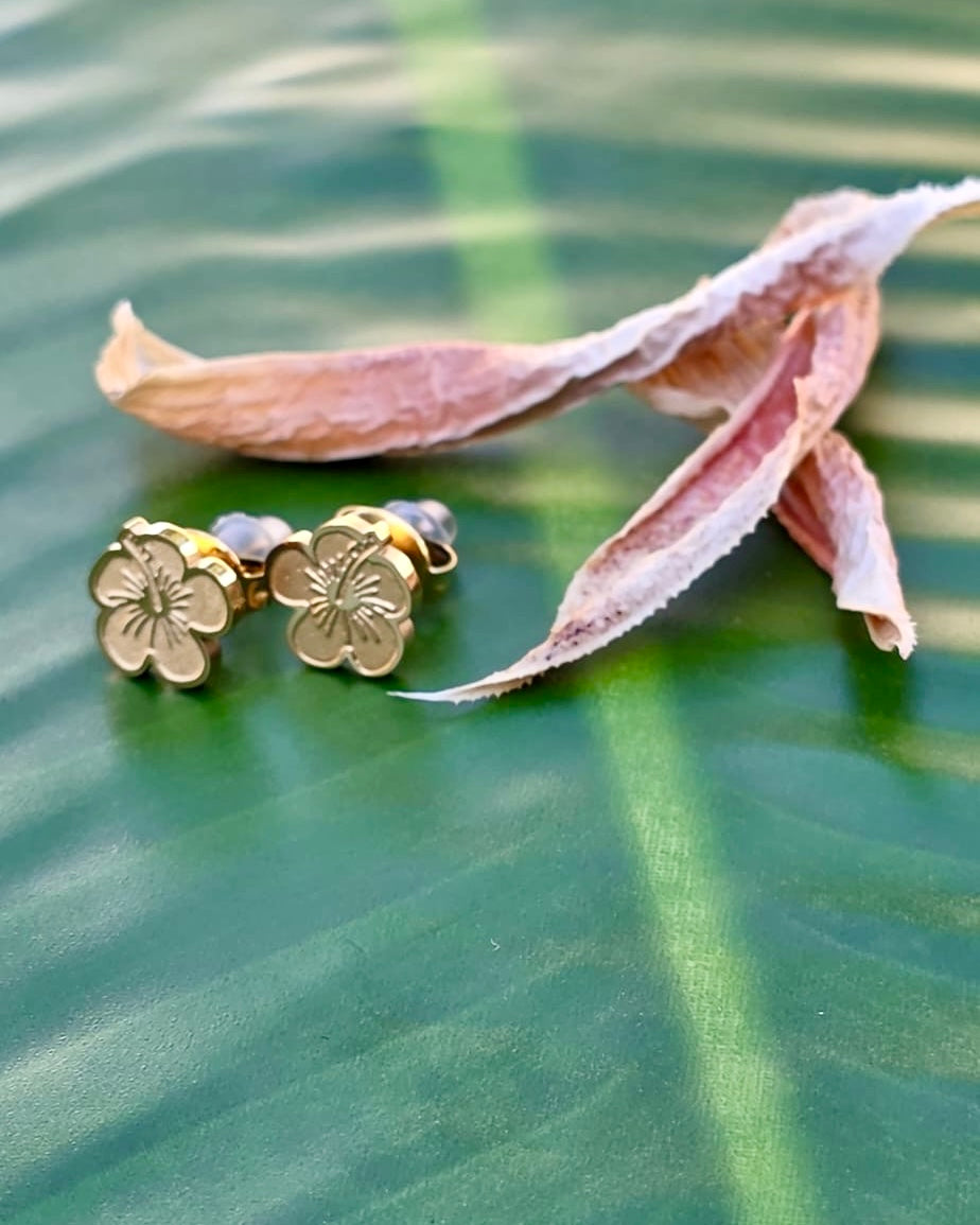 Small Flor de Maga stainless steel studs feature earrings in gold and silver tones made in Stainless Steel, inspired by Puerto Rico’s national flower.