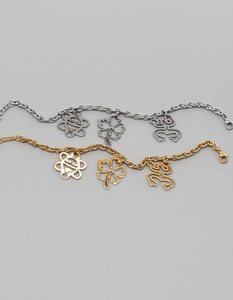 Stainless steel bracelet with Coquí Taíno, Flor de Maga, and Sol Taíno charms in gold or silver.