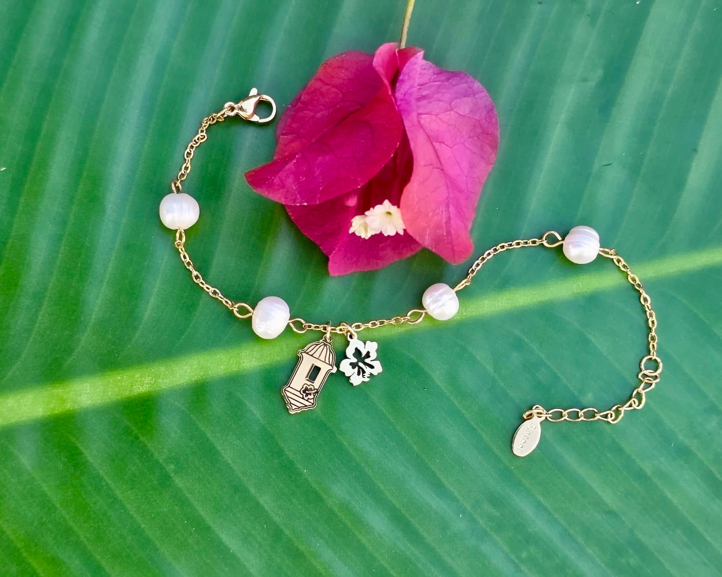 Gold stainless steel bracelet pearl Garita del morro charm, and Flor de Maga flower, inspired by Puerto Rican culture.