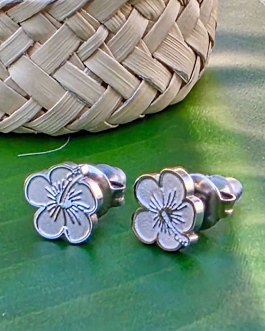Small Flor de Maga stainless steel studs feature earrings in gold and silver tones made in Stainless Steel, inspired by Puerto Rico’s national flower.