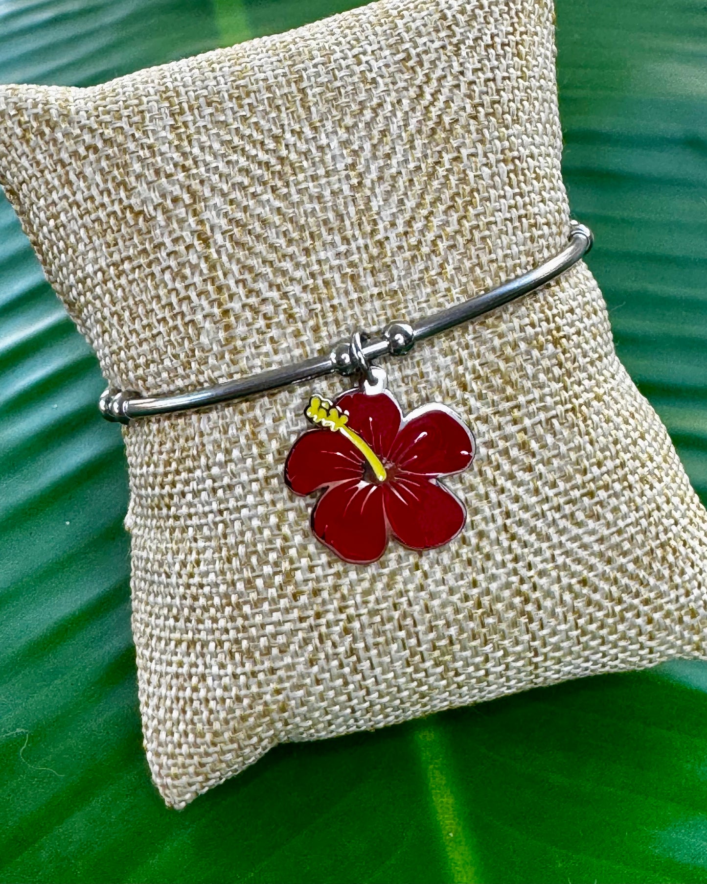 Stainless steel open bangle with a colored Flor de Maga charm.