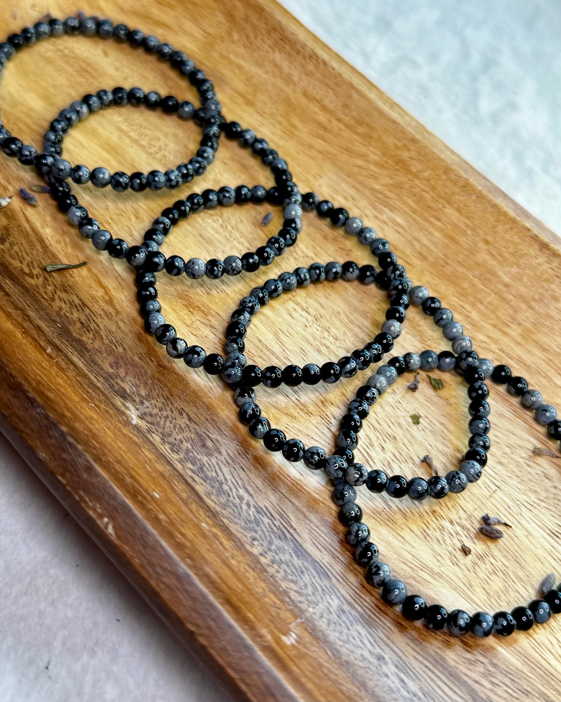 4mm Snowflake Obsidian bracelet with small black beads featuring natural gray snowflake patterns.