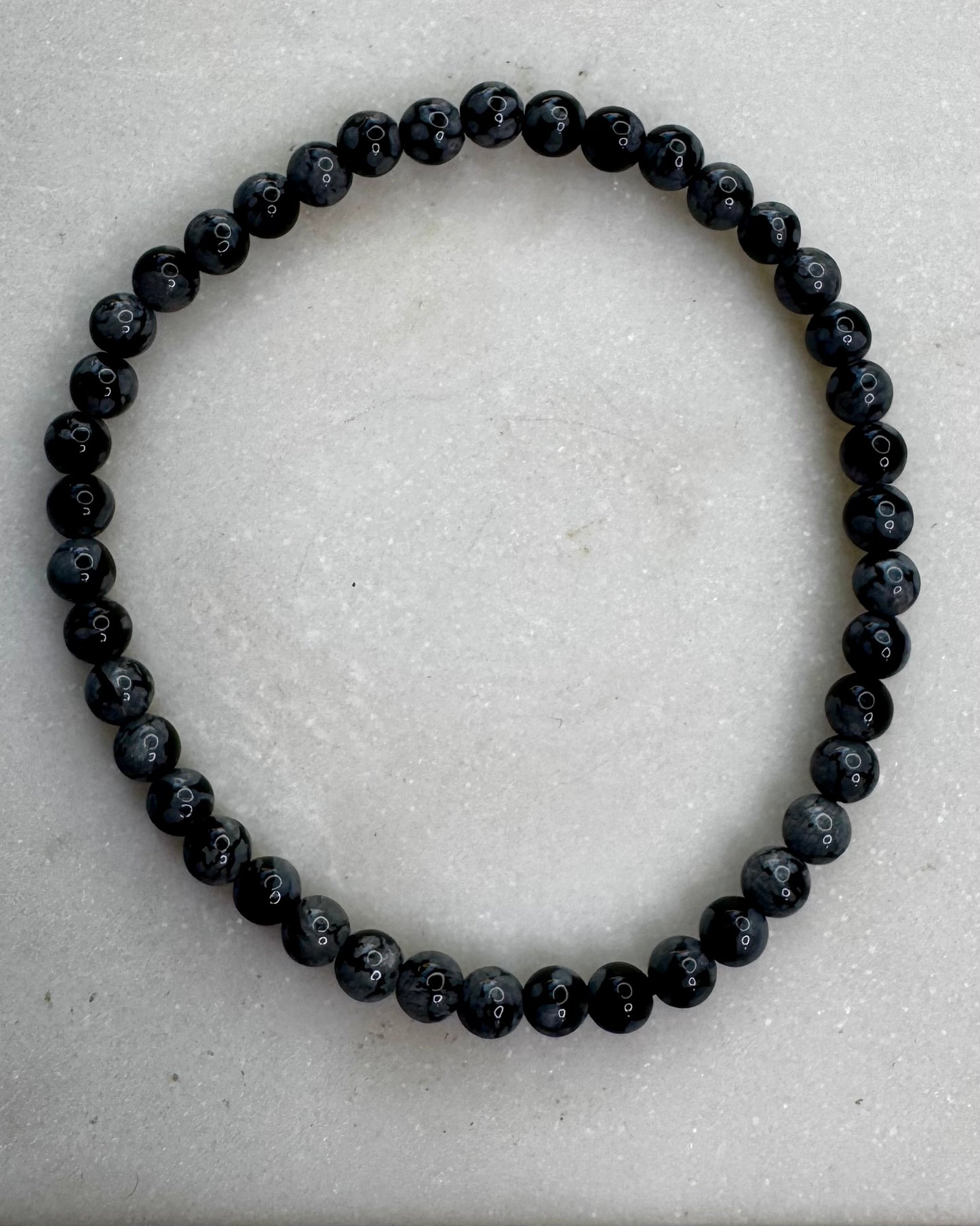 4mm Snowflake Obsidian bracelet with small black beads featuring natural gray snowflake patterns.