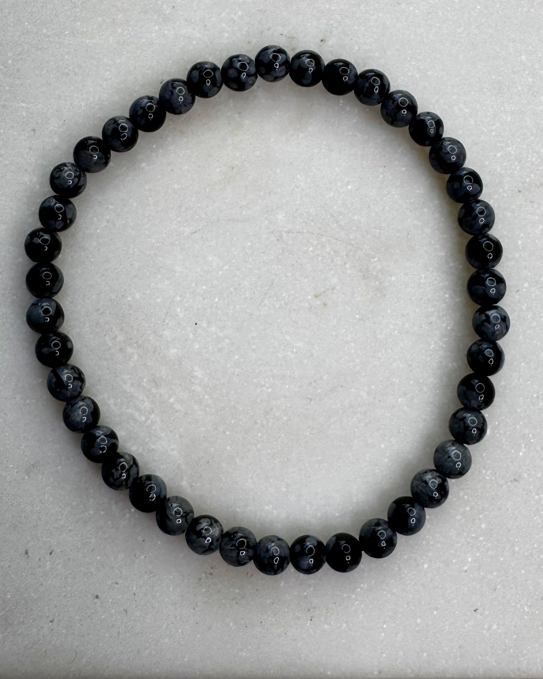 4mm Snowflake Obsidian bracelet with small black beads featuring natural gray snowflake patterns.